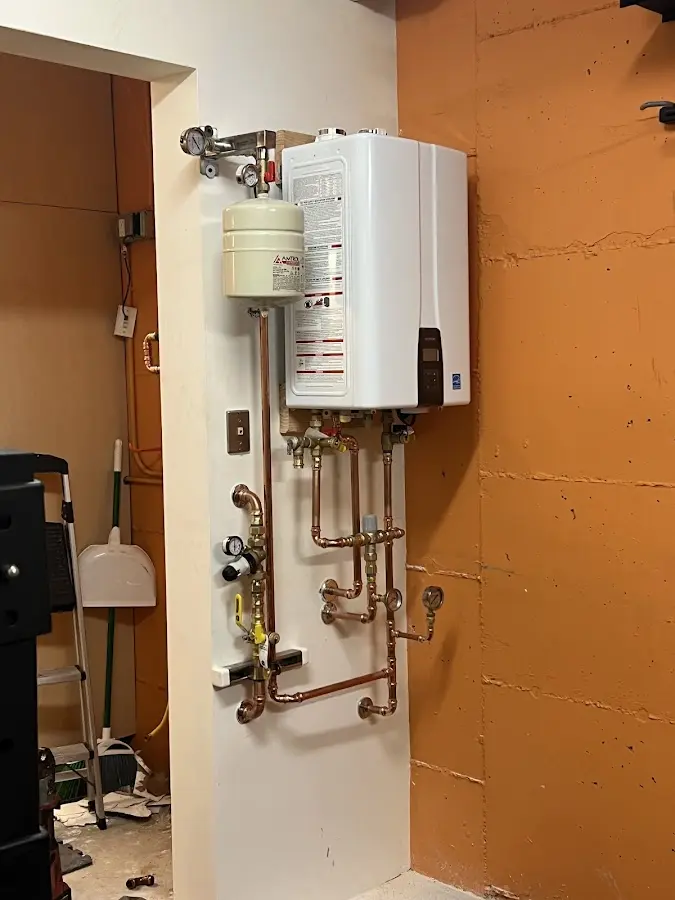 Plumbing technician inspecting water heater connections in Crawfordville